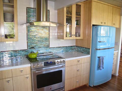 Interior designers kitchens inspired by an iconic 1950s design feature pastel accent colors in tile backsplashes and modern throwback appliances. 